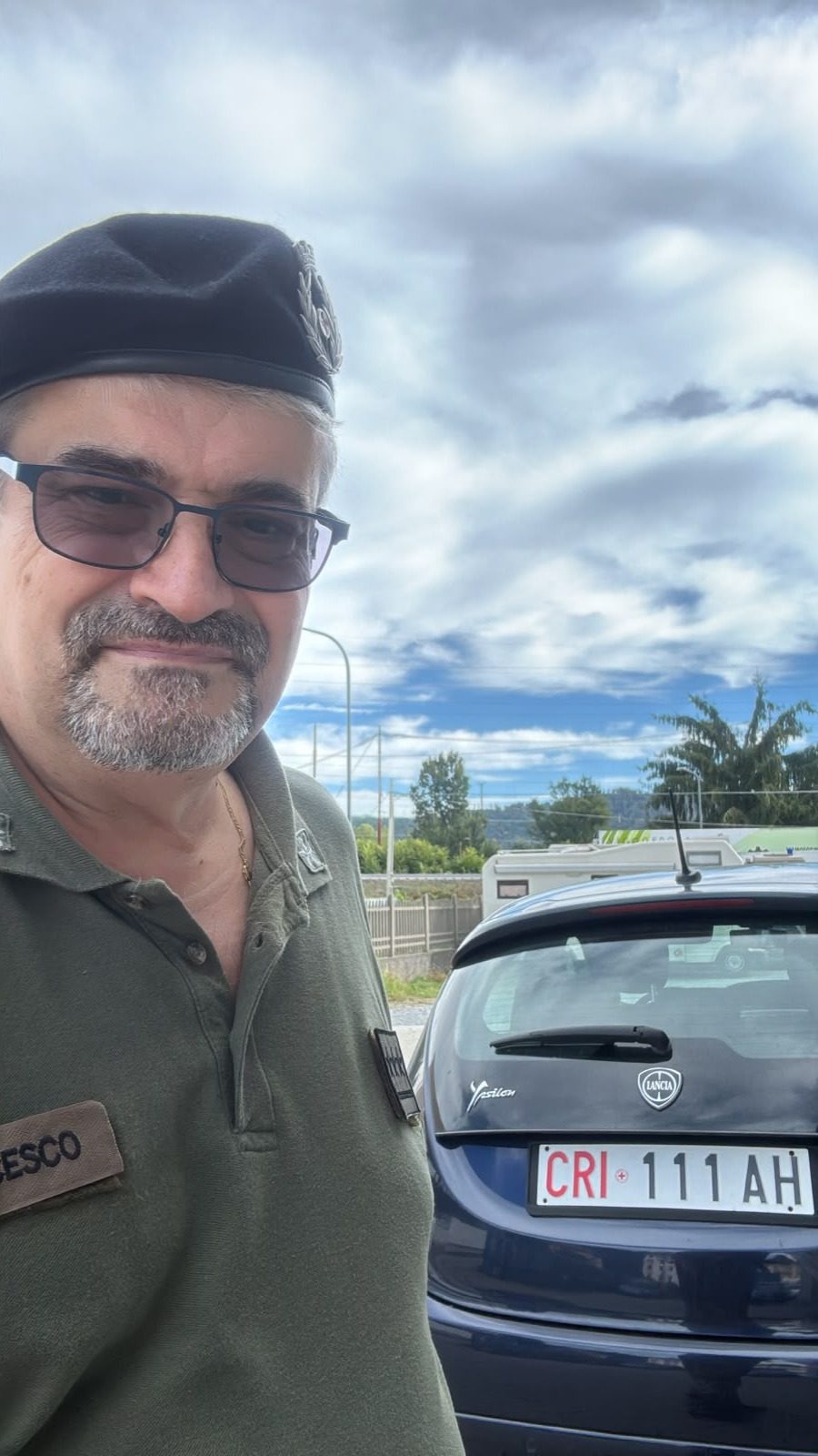 Con il basco del Corpo Militare, accanto a un'auto della Croce Rossa