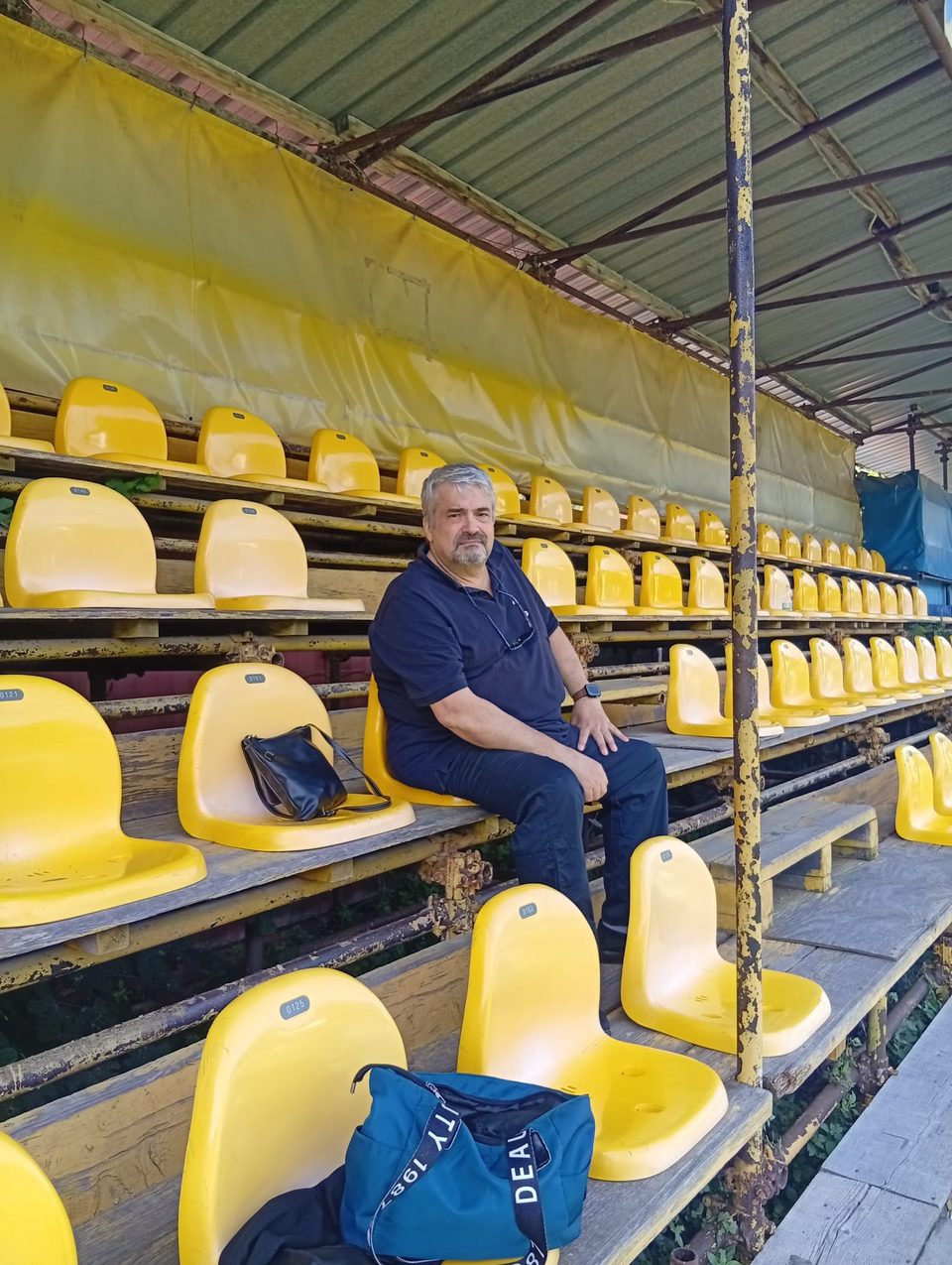 Seduto in tribuna al campo sportivo